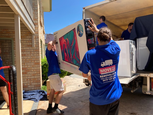 Two removalists carrying a couch